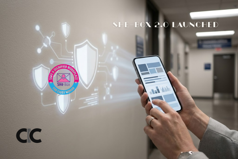 Woman holding a phone with a digital complaint interface, representing SHe-Box 2.0 for workplace sexual harassment complaints.