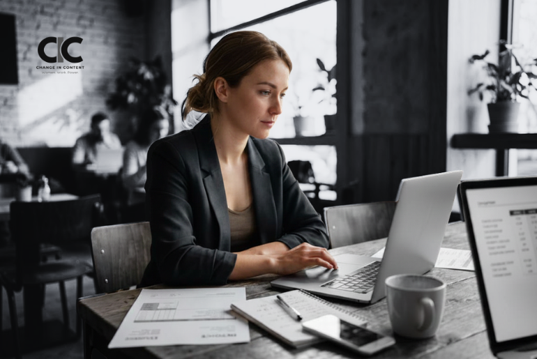 A woman freelancer working at a home desk with invoices and a laptop, representing the pay gap for women freelancers.