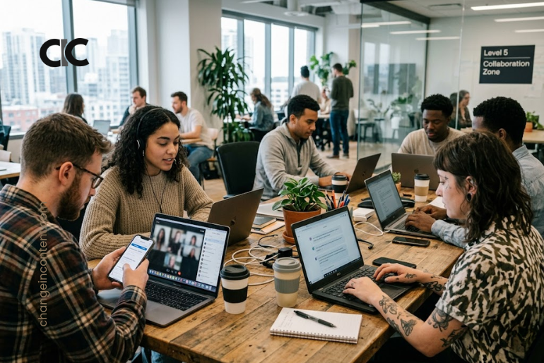 A modern hybrid office scene with young professionals using laptops, phones and AI tools, representing the hottest work trends of 2026.